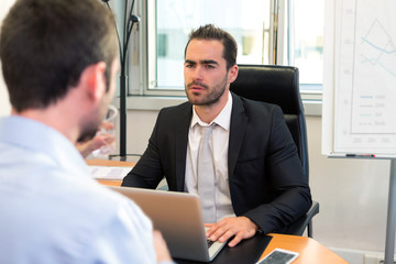 Fototapeta premium Attractive boss doing interview with his assistant
