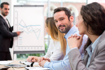 Fototapeta premium Young attractive businessman working at the office with associat