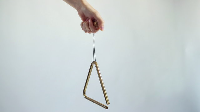 Hands play a musical triangle. Hit a few times on a white background