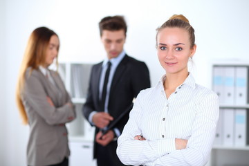 Pretty businesswoman in office with colleagues in the background