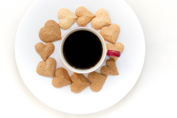 Chocolate cookies and butter cookies heart shape on white dish with black coffee