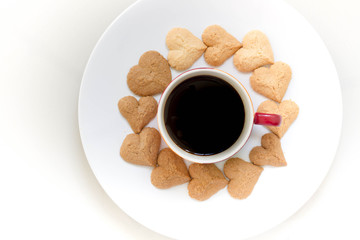 Chocolate cookies and butter cookies heart shape on white dish with black coffee