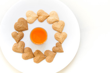 Chocolate cookies and butter cookies on white dish with carrot juice on white background