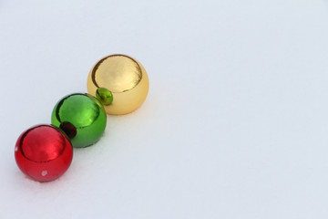 Glass color spheres lying in snow outdoors