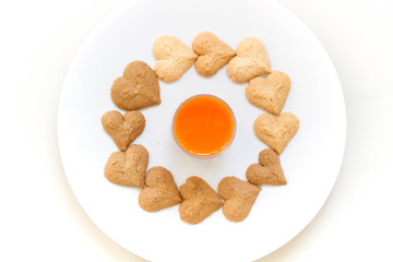Chocolate cookies and butter cookies on white dish with carrot juice on white background