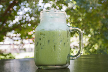 Cup of Green tea with ice fresh on the wooden table