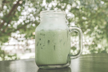 Cup of Green tea with ice fresh on the wooden table - Vintage Filter Effect