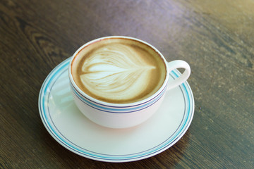 A cup of coffee latte on the wooden table