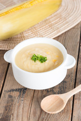 Corn cream soup in white bowl.