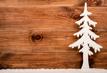 Decorative white christmas tree on the wooden background.