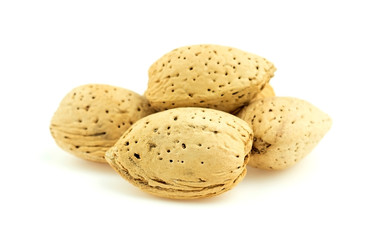 Pile of natural unshelled almond nuts against white background