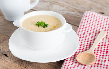 Corn cream soup in white bowl.
