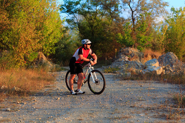 Fototapeta premium young adult cyclist riding mountain bike in the countryside