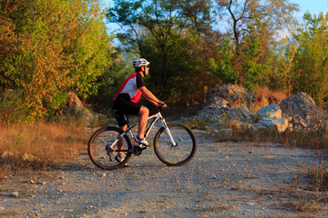 Fototapeta premium young adult cyclist riding mountain bike in the countryside