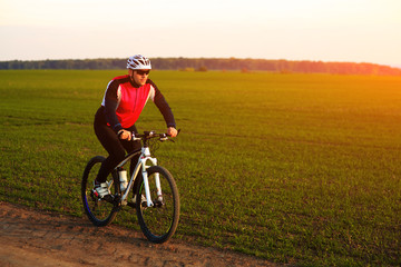 Fototapeta premium young adult cyclist riding mountain bike in the countryside