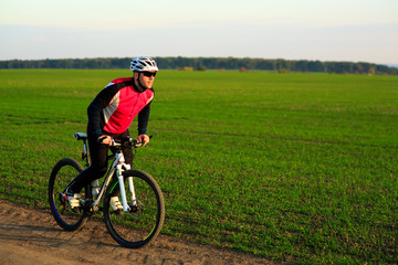 Fototapeta premium young adult cyclist riding mountain bike in the countryside
