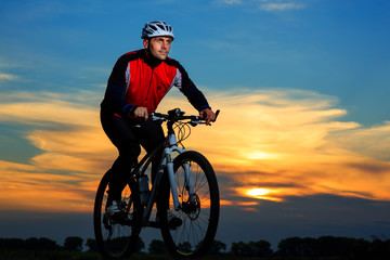 young adult cyclist riding mountain bike in the countryside