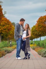 Fototapeta na wymiar Pregnant couple - walking at the autumn park
