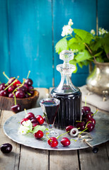 Fototapeta na wymiar Cherry homemade liquor in a vintage bottle with fresh cherries.