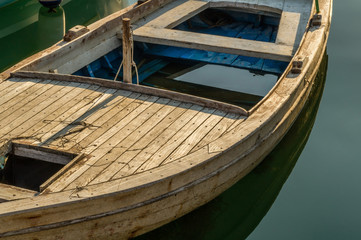 Fototapeta na wymiar Wooden retro boat almost full of seawater and lonely stands afloat. 