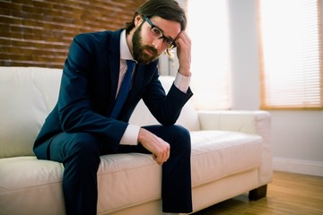 Upset businessman sitting on the couch