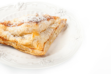 Cream puff with powdered sugar on the white background horizontal