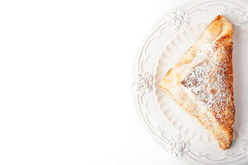 Cream puff with powdered sugar on the white plate top view