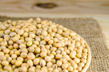 soy bean on wood plate with sack on wood panel