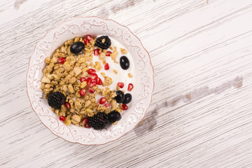 Crunchy granola with nuts, yogurt and fresh berries. Healthy breakfast concept. Top view