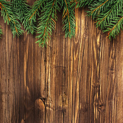 Christmas wooden background with fir tree branches. Toned image. Retro style. Square image