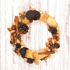Xmas wreath made of cookies, nuts, cones and spices. Space for text