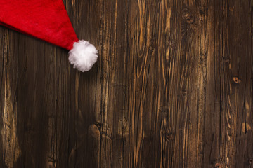 Obraz na płótnie Canvas Santa's hat over old grunge wooden background. Xmas greeting card. Toned image