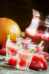 Cocktail with vodka, soda and grapefruit with striped straws, se