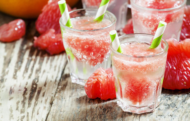 Cocktail with vodka, soda and grapefruit with striped straws, se