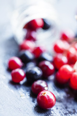 Cranberry, mountain ash, viburnum, chokeberry in a glass jar on