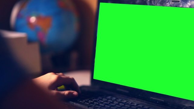green key teenage boy playing computer close-up hands game video sitting back room evening