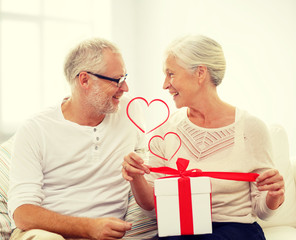 happy senior couple with gift box at home