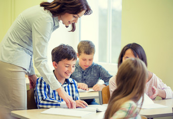 group of school kids writing test in classroom