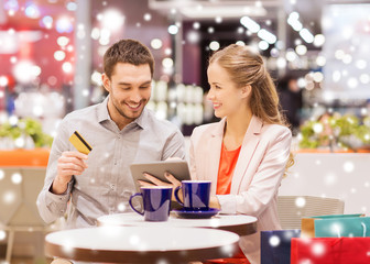 couple with tablet pc and credit card in mall