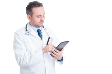 Doctor or medic using credit  card and wireless tablet