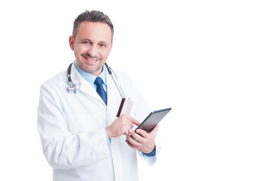 Smiling doctor or medic using credit  card and wireless tablet