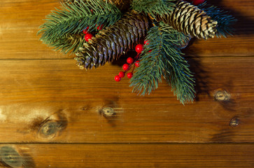 close up of fir branch with cones on wooden table