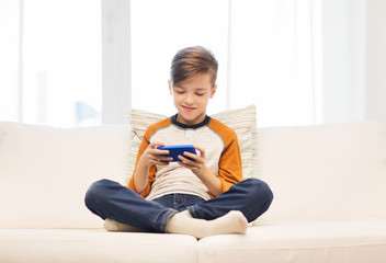 boy with smartphone texting or playing at home