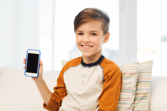 smiling boy with smartphone at home