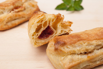 Pastry with quince jam inside on wooden background, traditional Romanian dessert