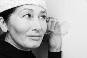 Middle aged woman listening in to a conversation next door