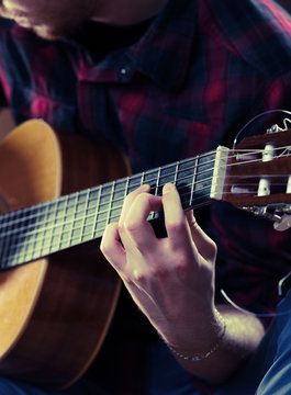 Young man playing acoustic guitar during a concert. - Vintage co