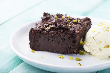Fototapeta na wymiar Chocolate brownie, cake, white plate on a turquoise wooden background