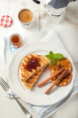 French toasts with orange marmalade, grilled apples and cinnamon sticks.