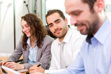 Young attractive businessman working at the office with associat